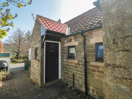 Entrance door of a stone house with small windows and tiled roof at Glaisdale in Glaisdale