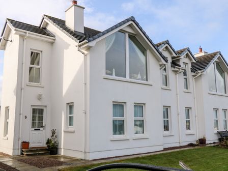 A white two-story house with multiple windows and a front door with plants at Seaview in Castlerock