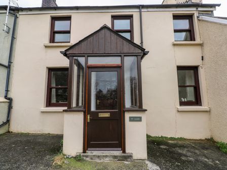 A front door with a glass porch and four windows on a two-story house at Ty Canol in Mathry Pembrokeshire