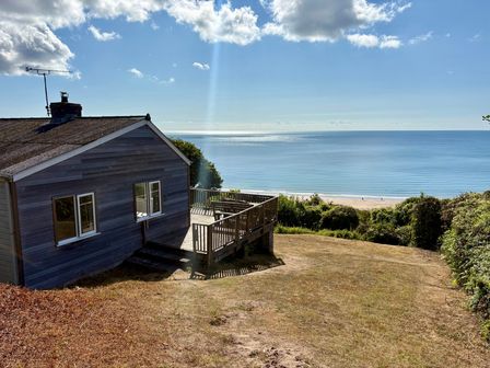 A house with a deck overlooking the sea at Beach Cove in Freshwater East, Pembrokeshire