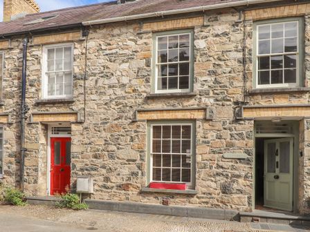 Stone terrace house with a red door and green door and sash windows at Carnorfa in Newport Pembrokeshire
