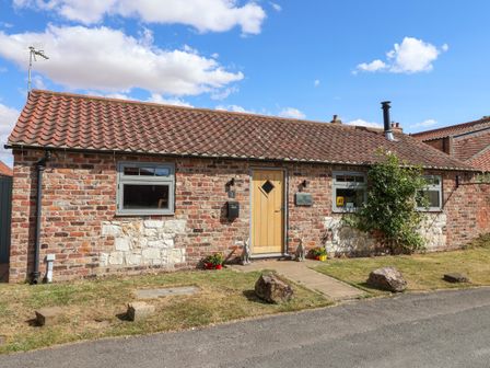 An outdoor area of a property featuring a brick wall and a pathway at 1 Church Barns Pocklington