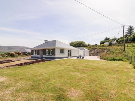 A single story house with a lawn and stone walls at Coolnaharragill Lower Coolnaharragill near Glenbeigh County Kerry