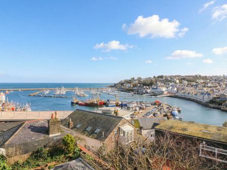 A harbor with boats and buildings overlooking the sea at Hidden Treasure in Brixham