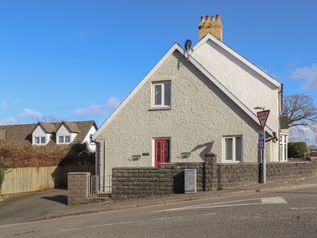 An exterior of a house with a red door and a give way sign on the street at Y Bwthyn Newport
