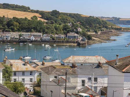 A coastal town with houses near water and boats docked in the harbor at The Water House in Falmouth