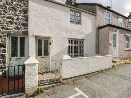 Row of terraced houses with front doors and small gated patios at 3 Alma Terrace in Llanfairfechan