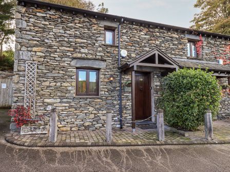 Stone cottage exterior with wooden door and small windows at Bobbin Cottage in Ings