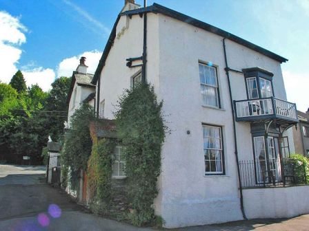 A white two-story house with a small balcony and ivy on the wall at Scafell in Ambleside