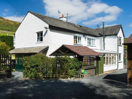 Exterior view of a white two-story house with multiple windows and a gravel driveway at Reston Mill at Staveley Nr Windermere in Staveley