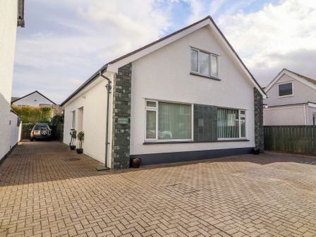 A white house with driveway and parked car at Bowderstone in Keswick