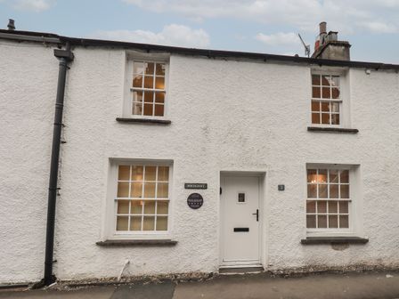 A white exterior of a house with four windows and a front door at Birchcroft in Ambleside