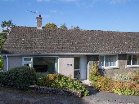 A single-story house with a tiled roof and a garden in front at Brimbles in Keswick