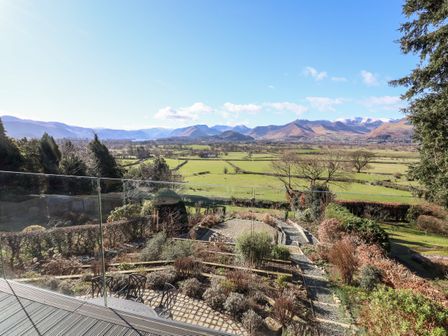 A garden with patio chairs and plants overlooking fields and mountains at Gillside in Millbeck