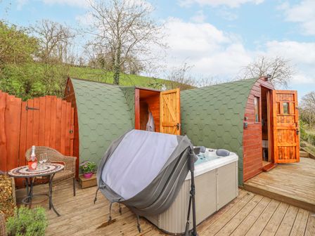 An outdoor area with a hot tub and wooden structures at The Rhiw in Llanfair Caereinion