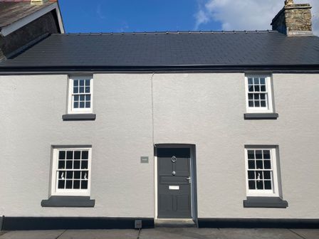Front view of a white house with black door and window frames at Awelfa in Newport Pembrokeshire