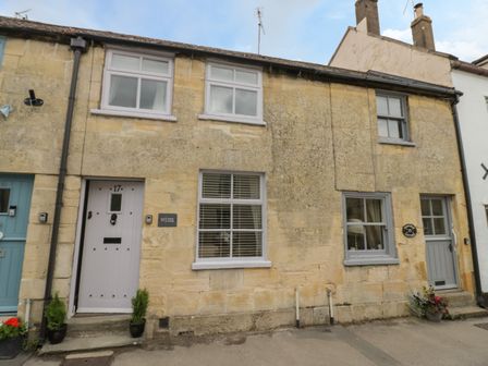 Stone cottages with doors and windows on a street at Thimble Cottage in Winchcombe