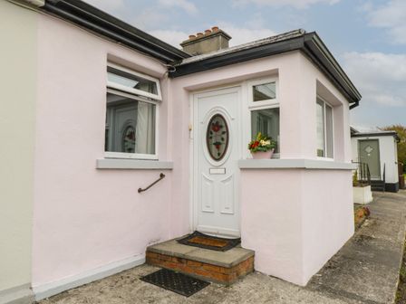 A white front door with stained glass and a small set of steps at 7 Aikenhead Terrace in Foxford County Mayo