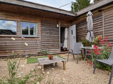 An outdoor seating area with a table and chairs at Tiny Willow in Farrington near Child Okeford