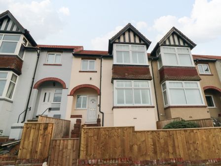 A row of terraced houses with tiled roofs wooden fences and white framed windows at 25 Victoria Park Avenue in Scarborough