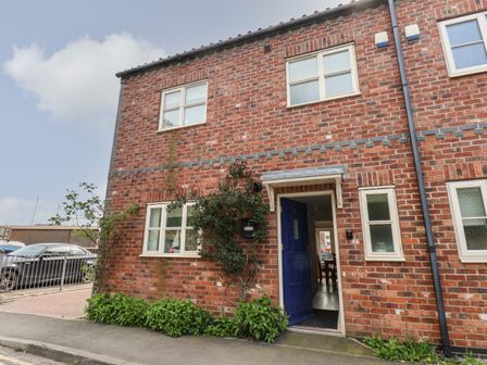 Exterior view of a brick house with a blue door and multiple windows at The Railway Retreat in Whitby