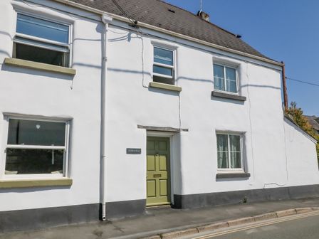 Exterior view of a white house with a green door and four windows at Old Town House in Dawlish