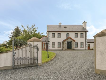 A two-story house with a gated gravel driveway and grass lawn at Redford View in Culdaff County Donegal