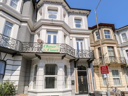 Exterior of a multi story building with balconies and a sign reading Clover Court in Great Yarmouth