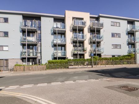 A modern apartment building with balconies and parking on a street at 23 Tre Lowen in Newquay