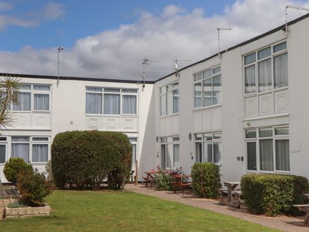 An outdoor area with buildings and bushes at Turtle Chalet in Dawlish Warren