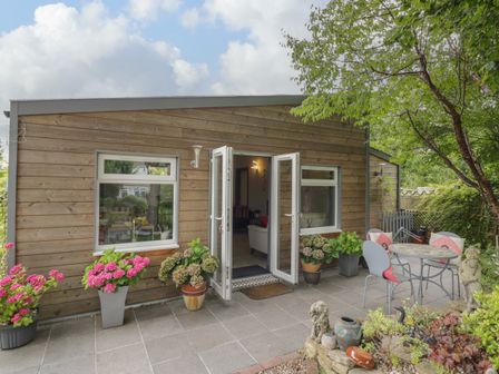 An outdoor patio area with potted plants and a table with chairs at The Garden House in Upper Quinton near Lower Quinton