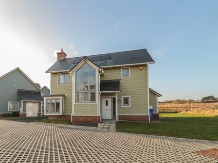A two story house with large windows and a driveway in front at The Deck House in Beadnell