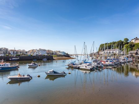 A harbor with boats docked and houses along the shore at Harbour View in Porthmadog