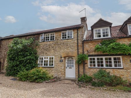 A house with a stone exterior and windows at Jasmine Cottage in South Perrott near Mosterton