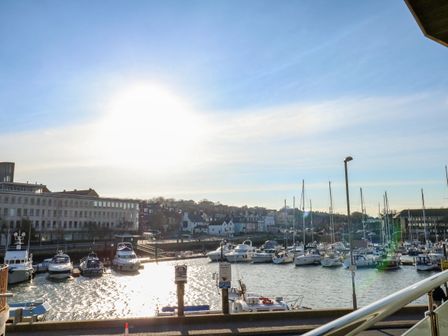 A marina with boats docked and buildings in the background at Harbourside Haven Apartment 2 in Weymouth