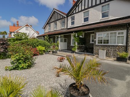 Exterior view of a semi detached house with a gravel garden and potted plants at 18 Tyn Celyn in Llandudno