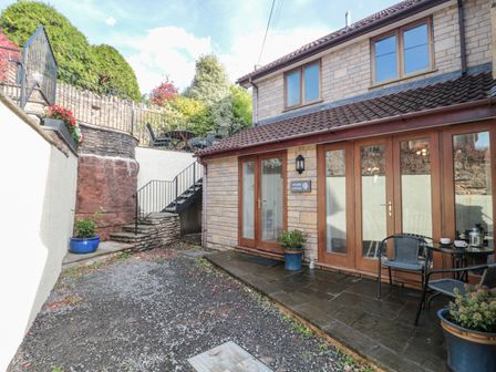 A patio area with stone steps and outdoor seating at Quarry Cottage in Draycott