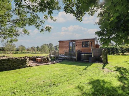 A cabin with a deck and hot tub at Stag Lodge Pod Llanfair Caereinion