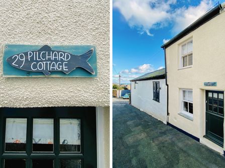 The exterior of Pilchard Cottage showing a white textured wall with a green door and windows on a narrow street in Brixham