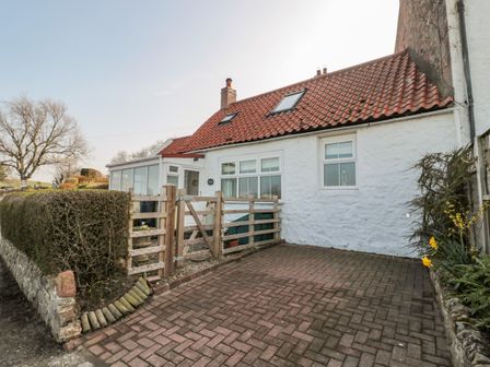 A white house with a red tiled roof and a paved driveway at Twincote in Wooler