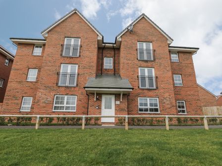A brick apartment building with multiple windows and a white door at Valley View in Whitby