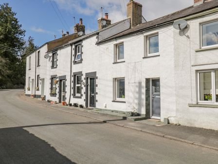 A row of white terraced houses along a quiet street at Sparrow Cottage in Keswick