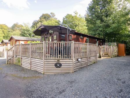 An outdoor space with a wooden lodge and decking at Badgers Hollow Lodge, Grasmere 30, White Cross Bay near Windermere