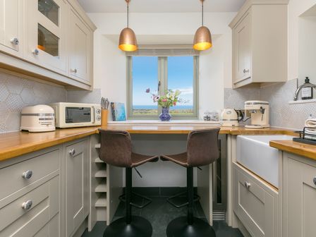 A kitchen with a sink and microwave at Scilly Stack in St Just
