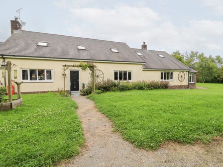 A house with a pathway in front and garden at Tynewydd Fields in Cross Inn