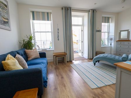 A living room with furniture including a sofa and a dresser at 4 The Beaches in Weymouth