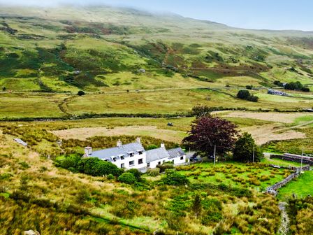 A house surrounded by grass and trees at Cwm in Capel Curig