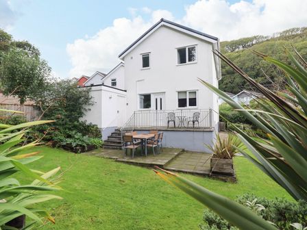 A house with a patio and seating area at Cwm Orthin in Borth-Y-Gest