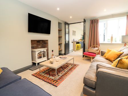 A living room with sofas camera table and fireplace near kitchen at Frans Nest in Keswick