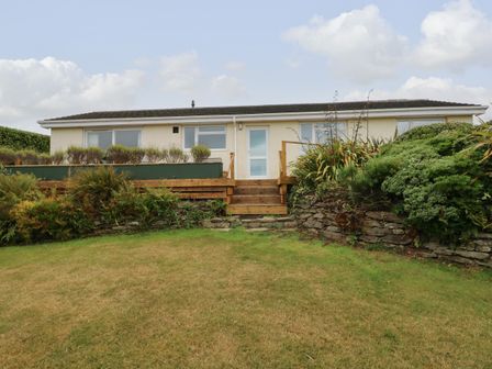 A single story house with a garden and steps leading to the door at Trem Y Morfa in Newport Pembrokeshire